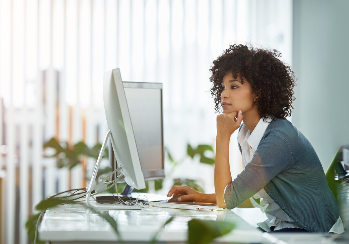 Shot of a young designer deep in thought while working on a computer in a modern office